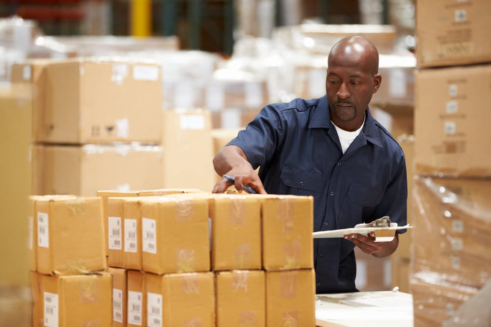 Man checking his shipping packages against a clipboard