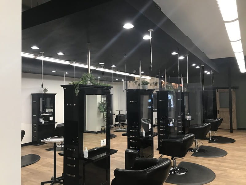 Hanging glass shields between hair style stations